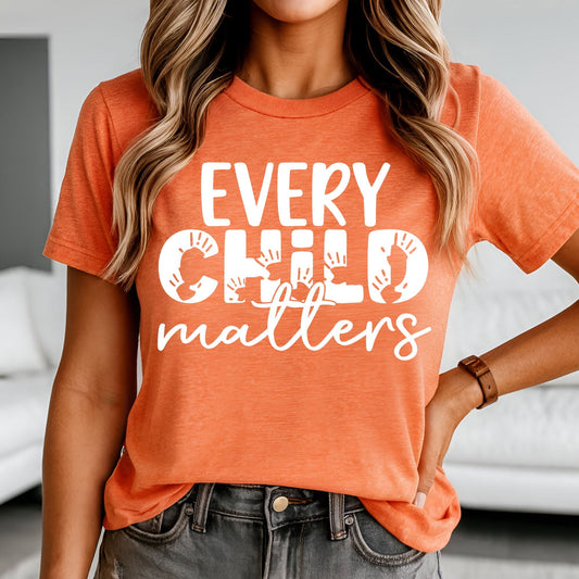 Every Child Matters white handprint lettering on orange shirt