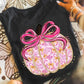 Pink and gold pumpkin with satin-style bow on black shirt